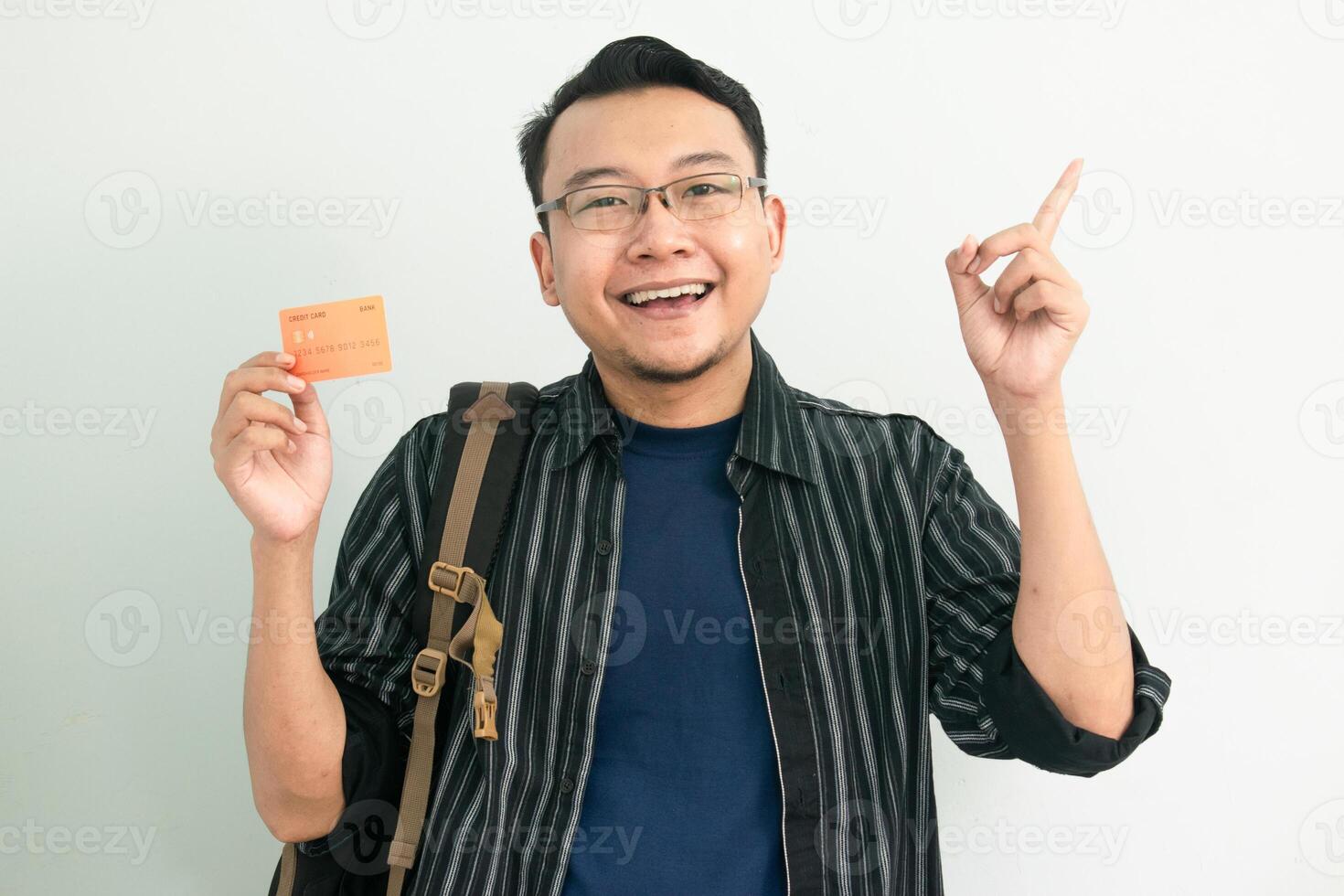 Smiling asian student hold credit card with pointing gesture. Banking, Financial isolated concept. photo