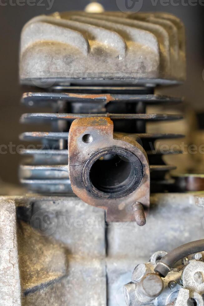 Close-up of rusty exhaust port on vintage motorcycle engine cylinder showing signs of wear and tear photo