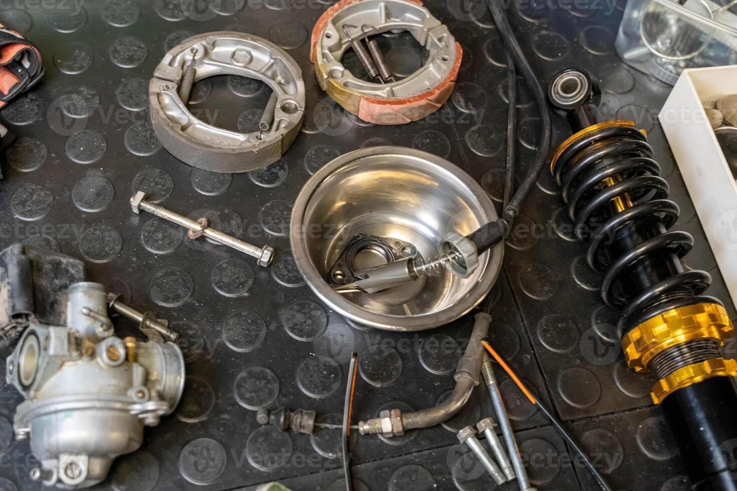 Motorcycle parts laid out on a workbench ready for maintenance photo