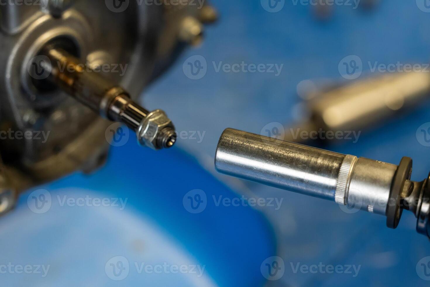Mechanic using socket wrench installing bolt into engine part photo