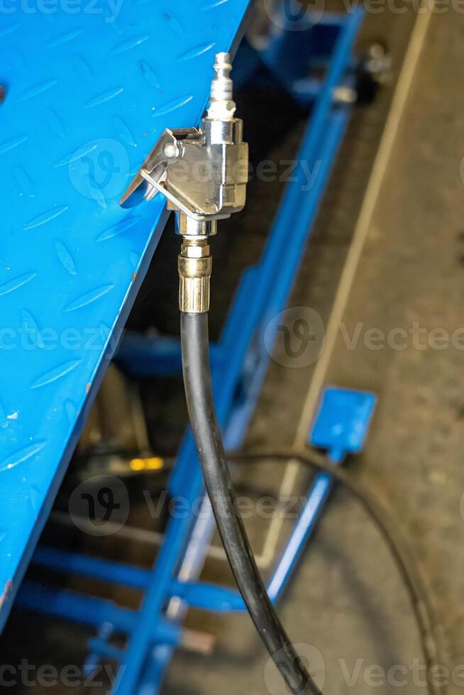 Pneumatic hose coupling connecting to a blue metal structure photo