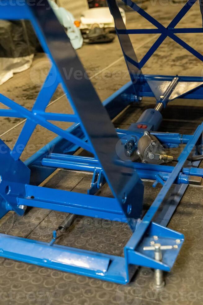 Blue hydraulic scissor lift table showing its lifting mechanism photo