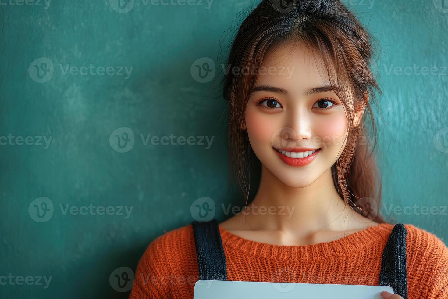 Young Woman Smiling Against Teal Background photo