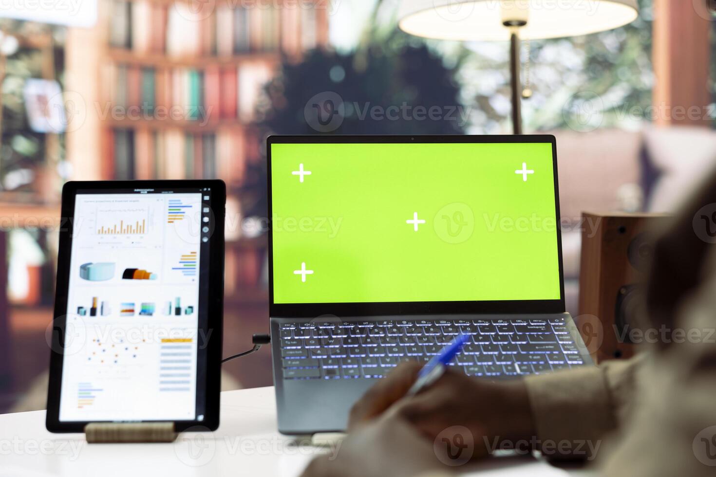 Entrepreneur writing down financial reports on a notebook next to isolated mockup, studying infographics and annual sales analytics. Businessman increasing the startup budget and funds. photo