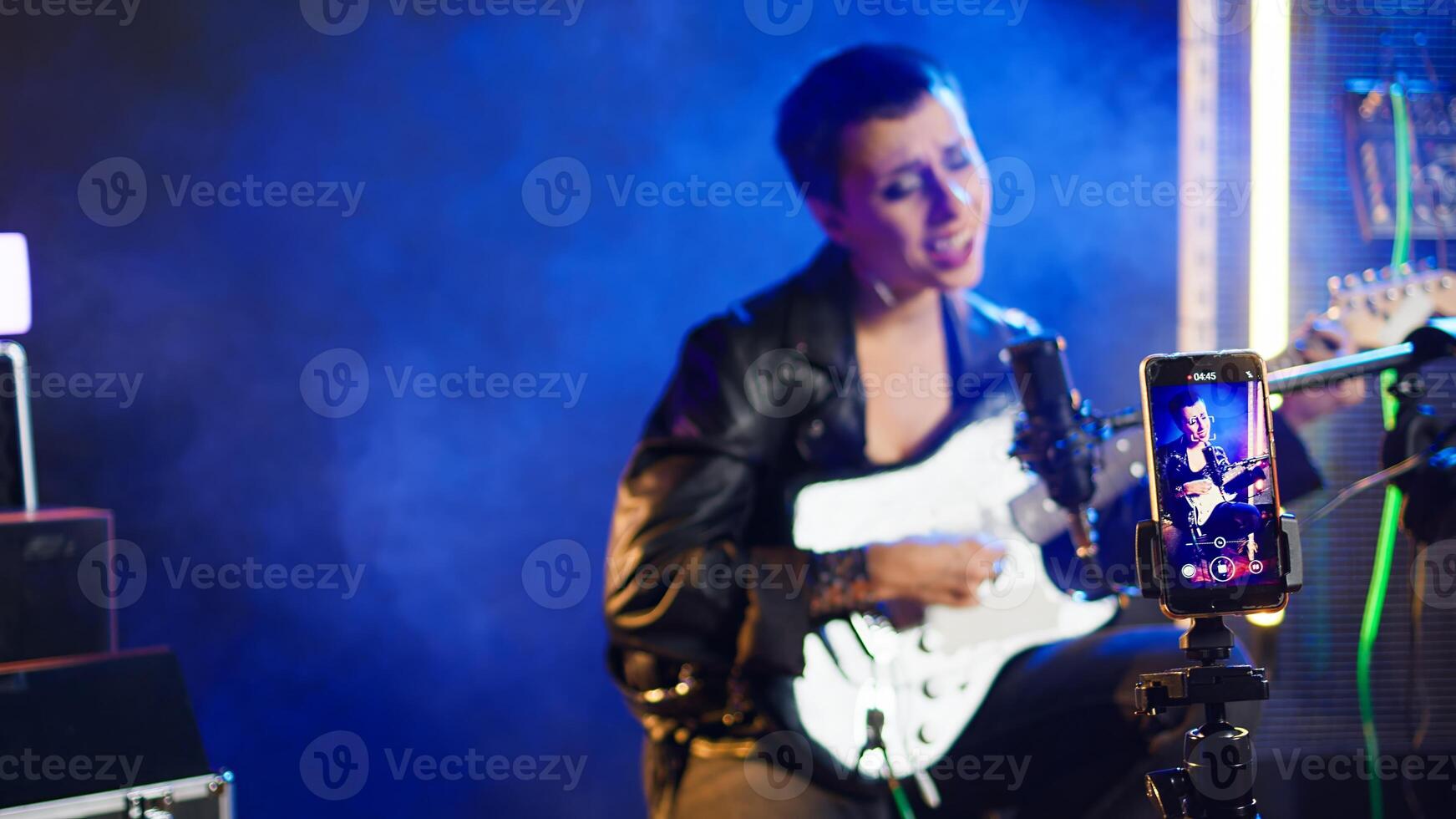 Social media artist live streaming a song for her music vlog, live event vocal performance online on internet. Content creator doing a broadcast for fan engagement, online concert. Camera A. photo