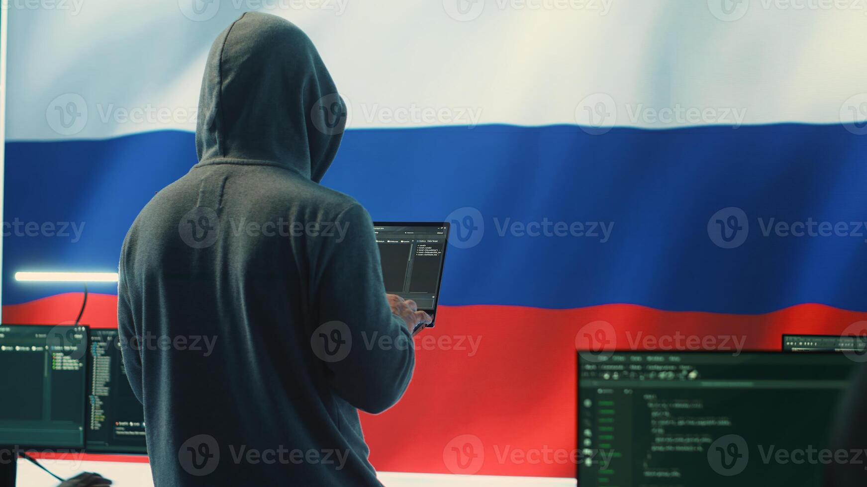 Propagandist person in a Russian cybersecurity center with the national flag works on installing fear and anxiety among the population by manipulation and brainwashing, cyber conflicts. Camera A. photo