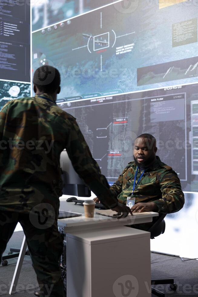 Soldier manages classified information and satellite cctv systems to gather intelligence for data processing, strategic planning. Military staff maintains national security with advanced technology. photo