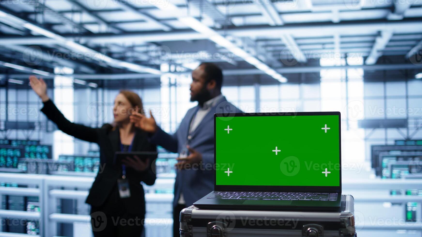 Green screen laptop used by engineers monitoring server room, doing checkup. Focus on chroma key notebook used by IT support employee working in data center facility, camera B close up photo