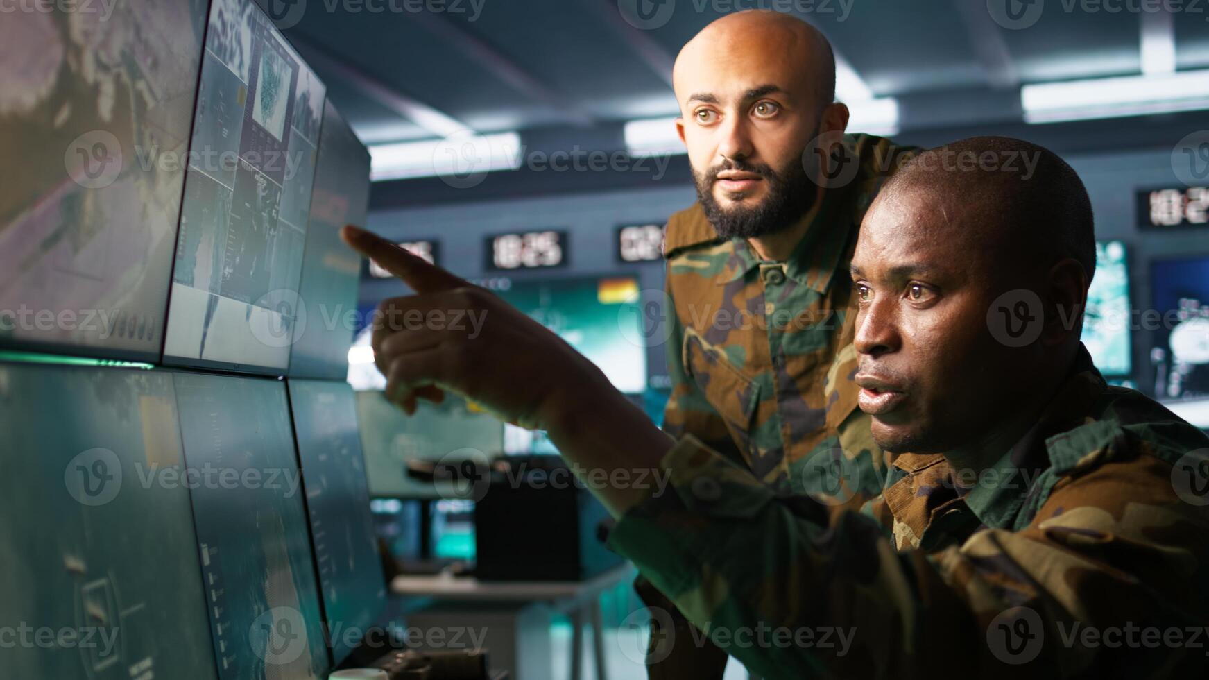 Army unit working in governmental facility next to colleague, operating surveillance monitoring tech with digital equipment. African american man doing job in base of operations, camera B photo