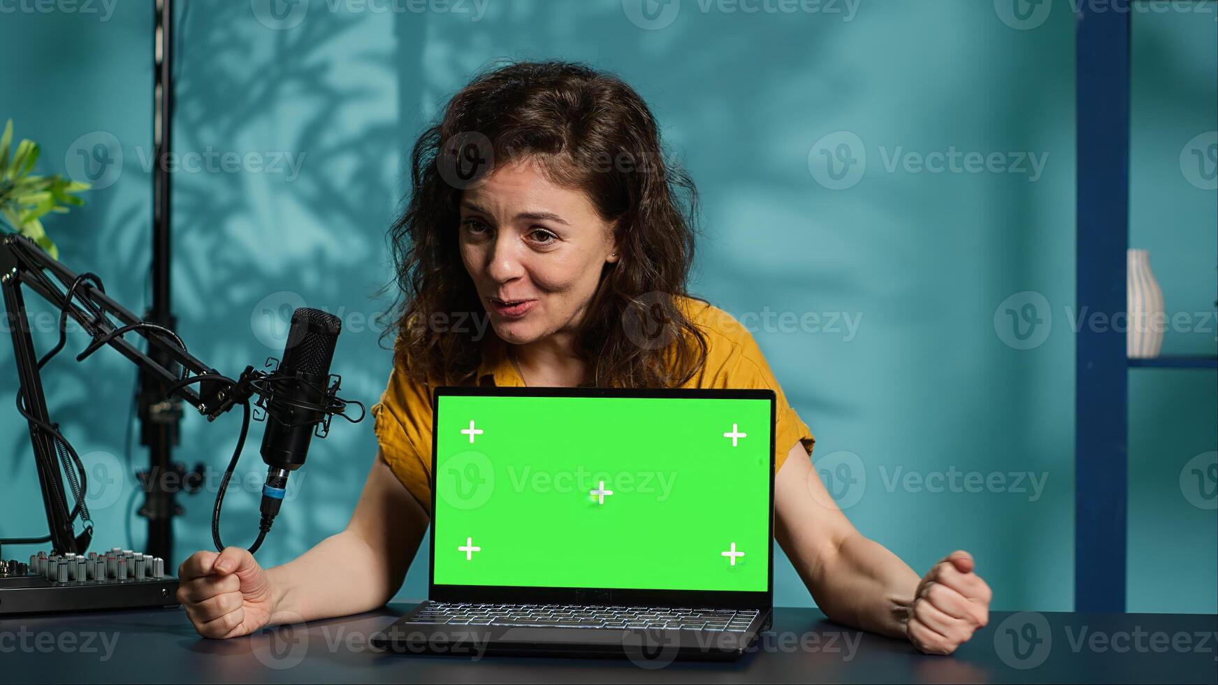 Happy content creator being sponsored by partnering brand to do green screen laptop unboxing. Upbeat technology guru does influencer marketing, doing mockup notebook product placement, camera A photo