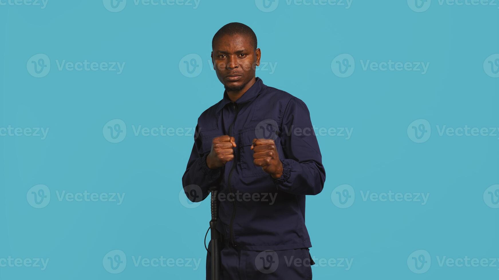 Security guard standing in fighting stance, prepared to deal with people entering restricted area. Portrait of bodyguard holding defensive pose, ready to throw punches, studio background, camera B photo
