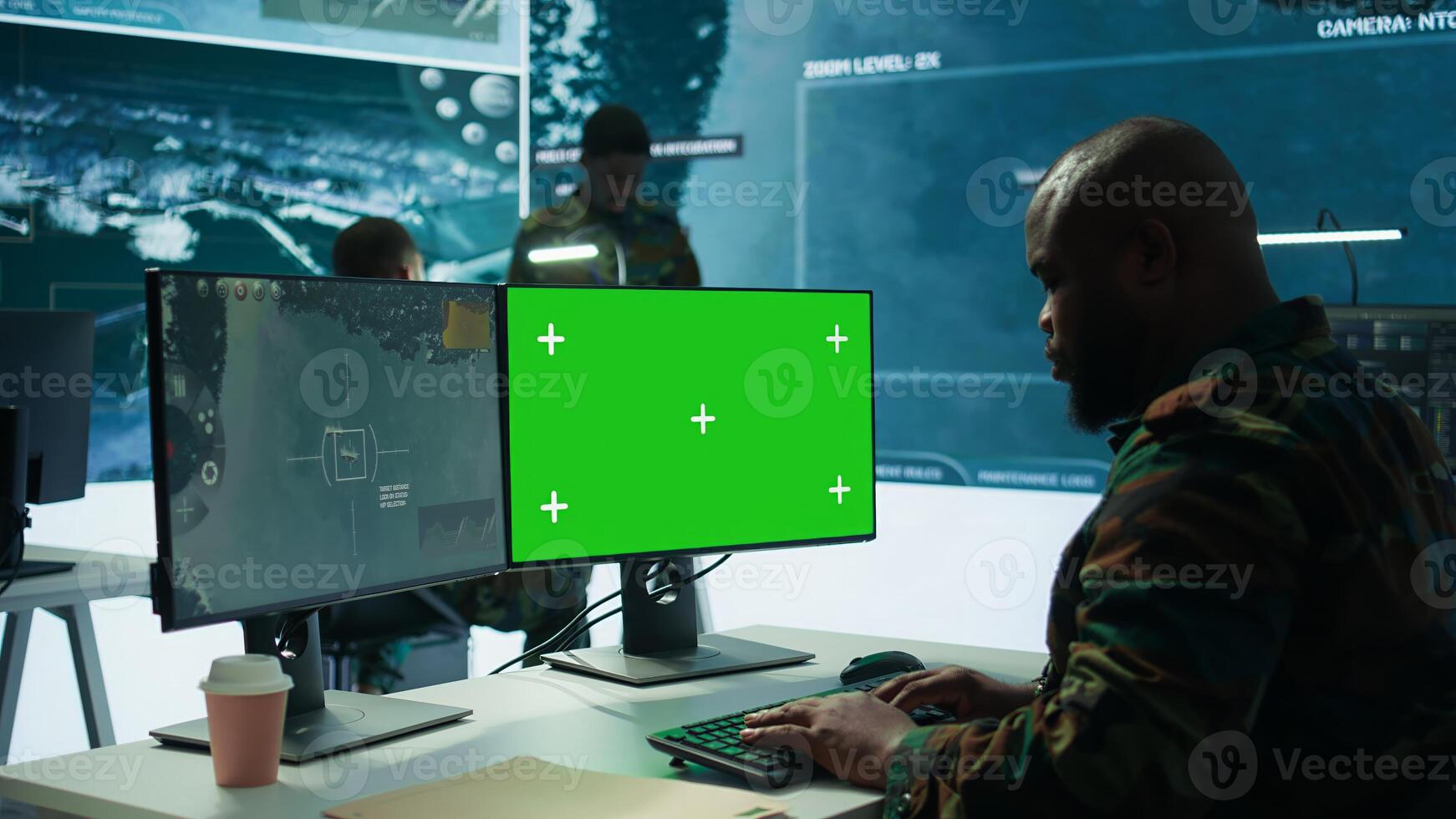 Army officer gathers intelligence from radar next to isolated copy space, working on satellite data monitoring from control room. Employs high tech gear and big screen in command post. Camera B. photo