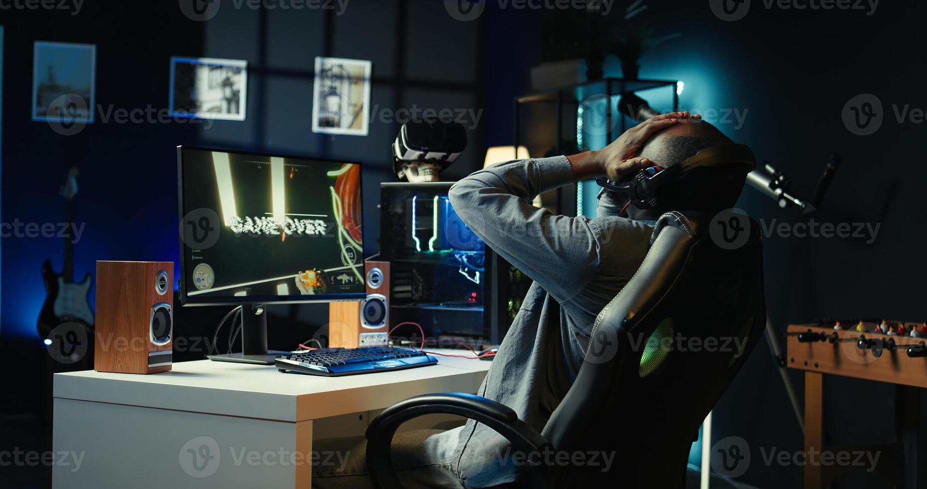 Man frustrated after receiving game over message on computer display while playing videogames on PC. Gamer annoyed after being defeated by opposing players in online competition, camera B photo