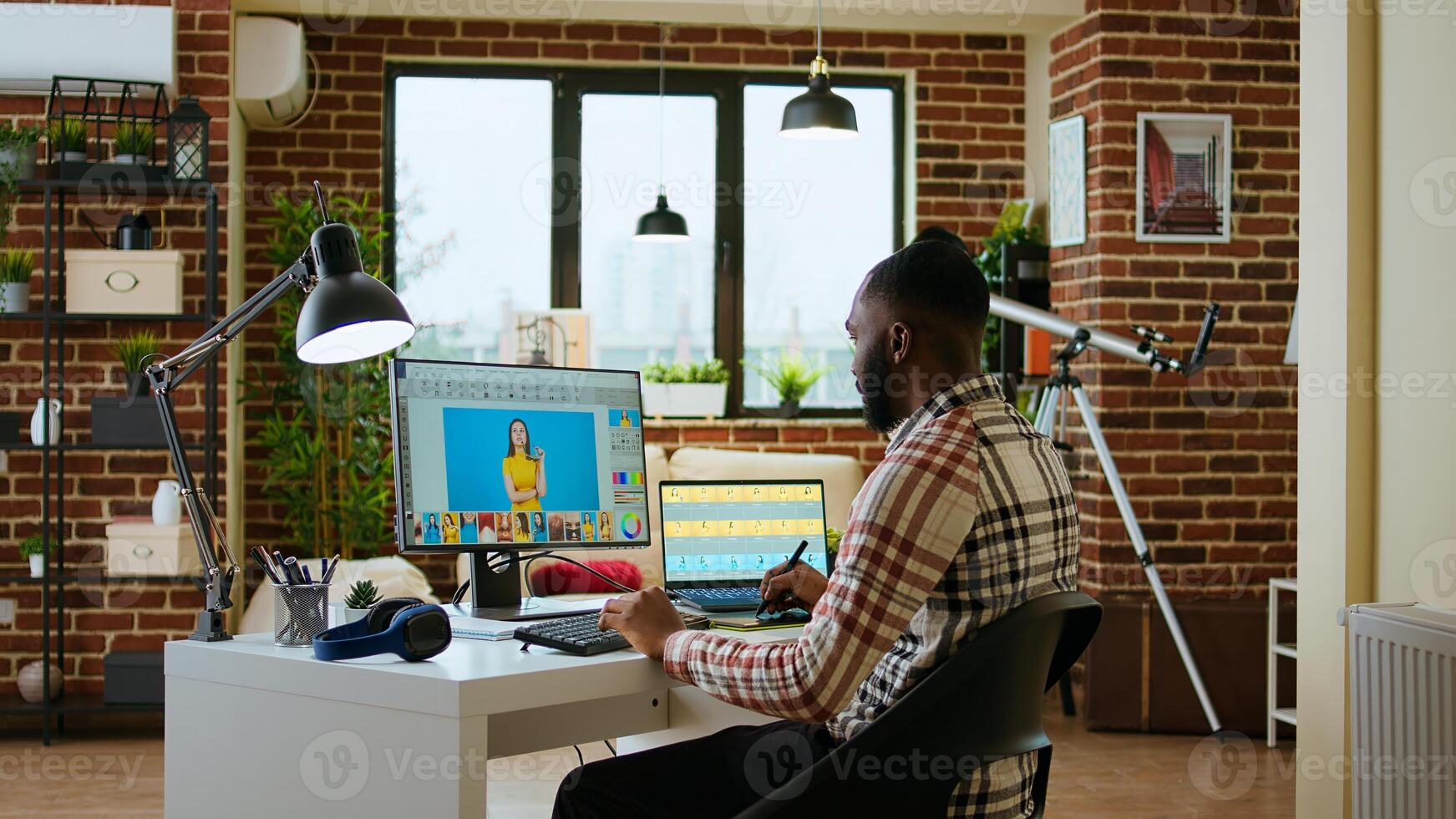 Freelance graphic designer editing photos on a modern computer setup in a remote office. Ideal workspace for a digital design professional, retouching digital pictures from home. Camera A.
