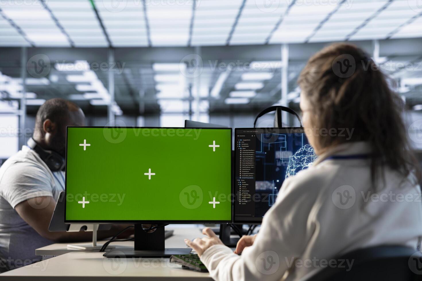 Isolated screen PC in front of IT support workers upgrading AI equipment. Engineers at PC desk overseeing artificial intelligence server clusters using chroma key computer photo