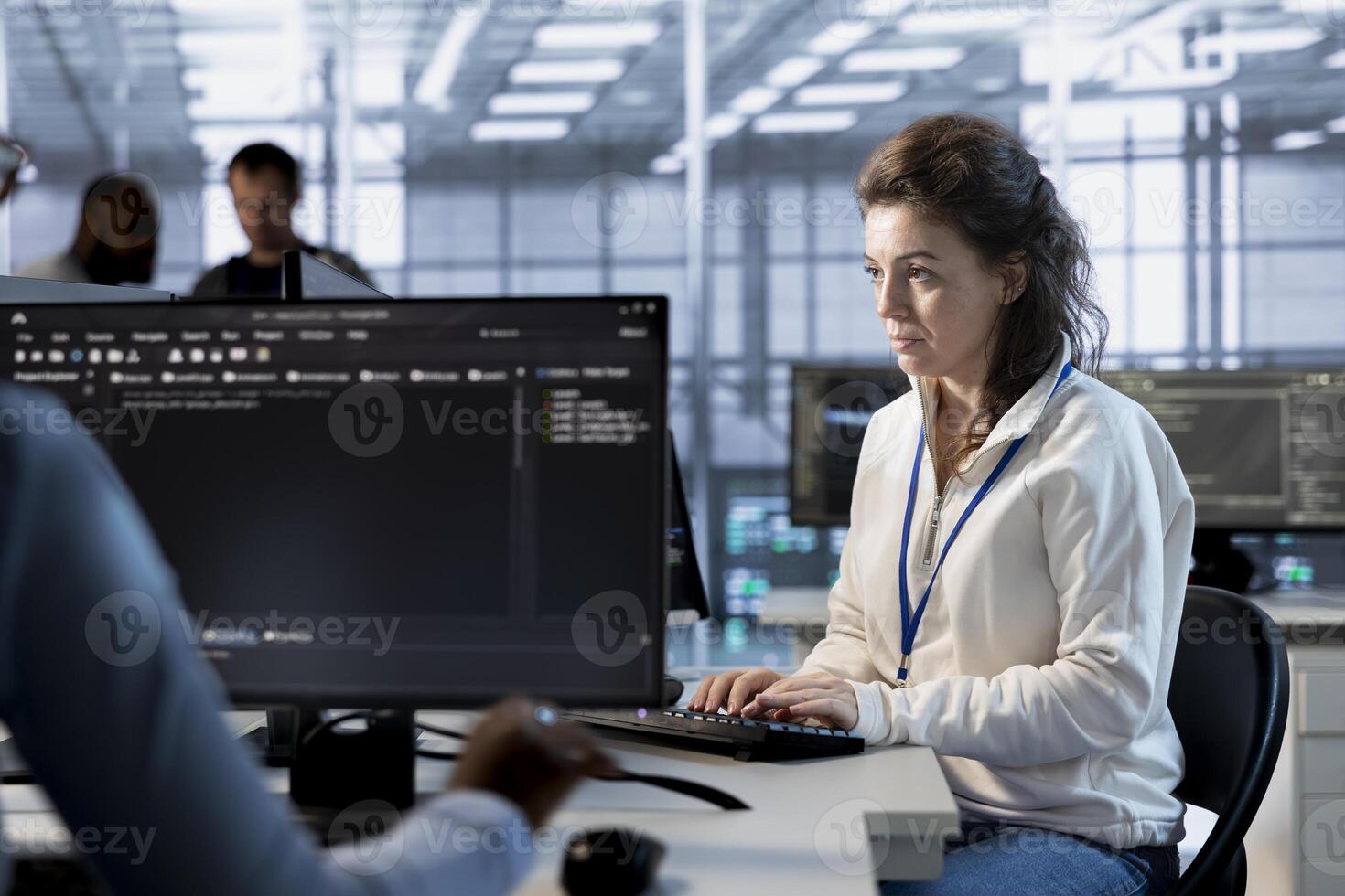 Programmer at work implementing cybersecurity measures to protect data center. Server hub facility IT specialist monitoring and analyzing metrics with device to enhance operational effectiveness photo