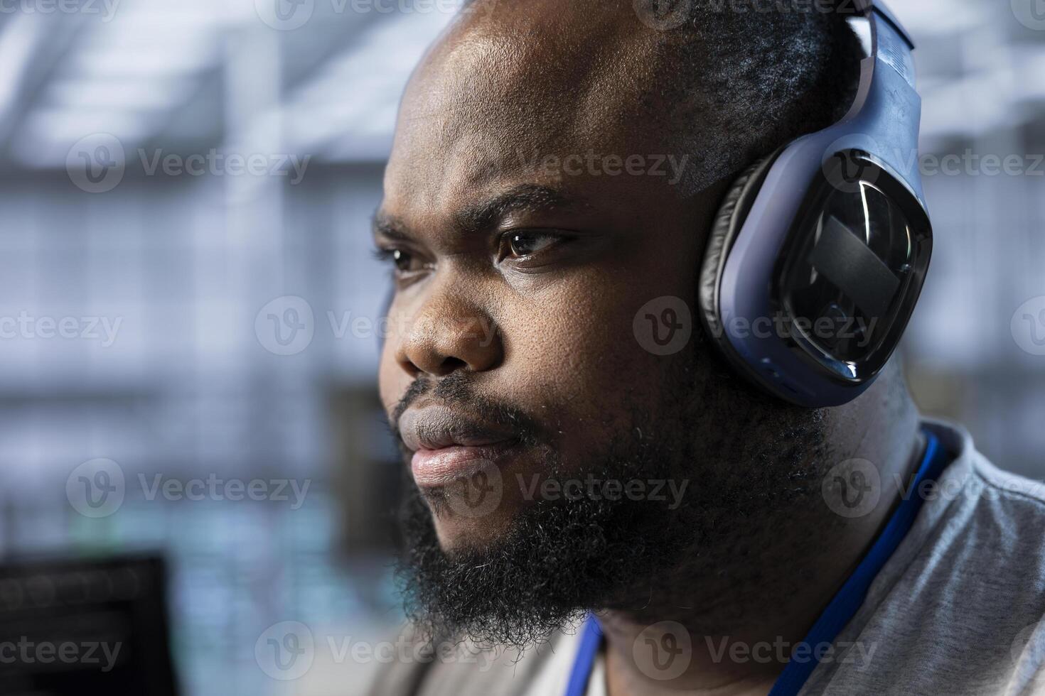 Close up of data center expert listening music and writing disaster recovery plans ensuring minimal downtime. Server farm technician wearing headphones uses analytics to monitor performance photo