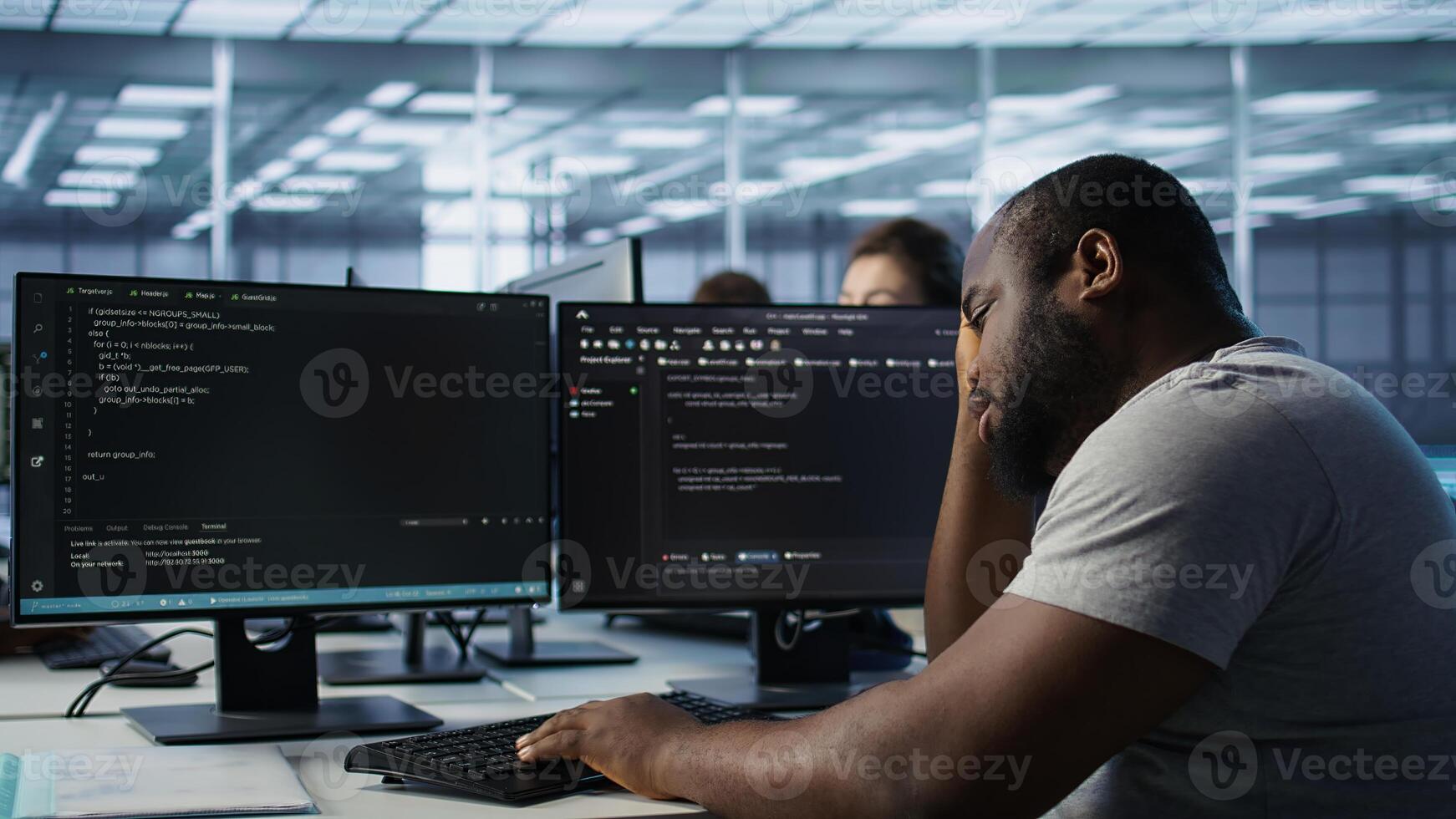 Overworked engineer falling asleep while typing on computer in server hub, monitoring data center energy consumption. Tired technician struggling to stay awake while inspecting rackmounts, camera B photo