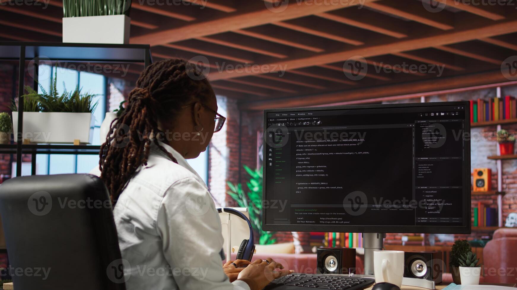 Programmer types code into PC, entering commands, running script. African american IT professional in apartment fixing errors in application, implementing new features, camera A photo