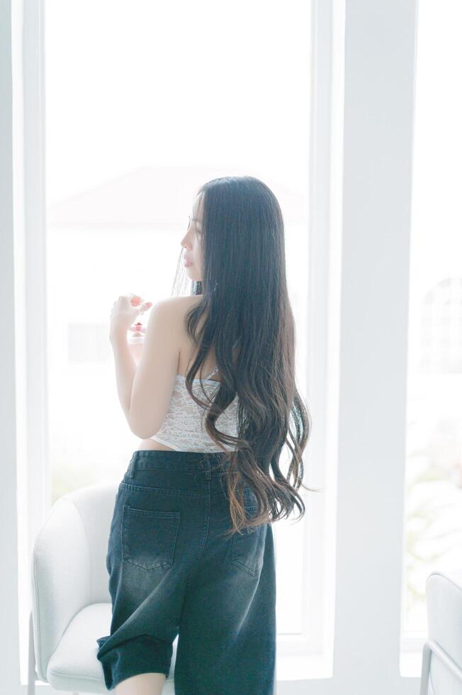 Woman with Long Hair in Casual Outfit by Bright Window photo