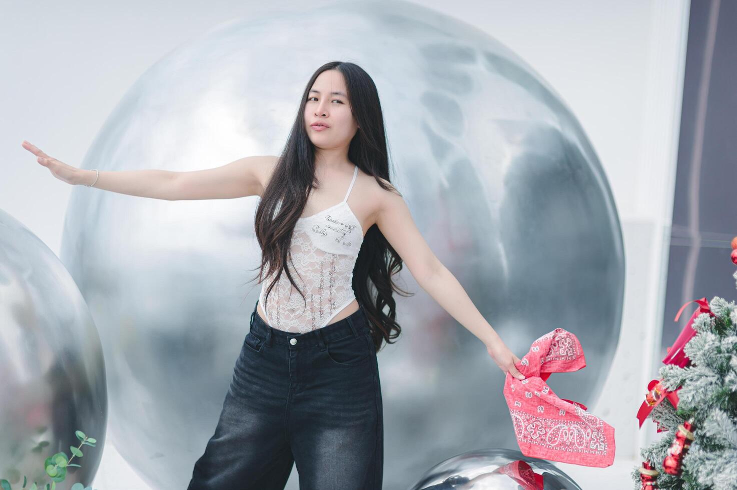 A woman in a white top and black pants is holding a gift photo