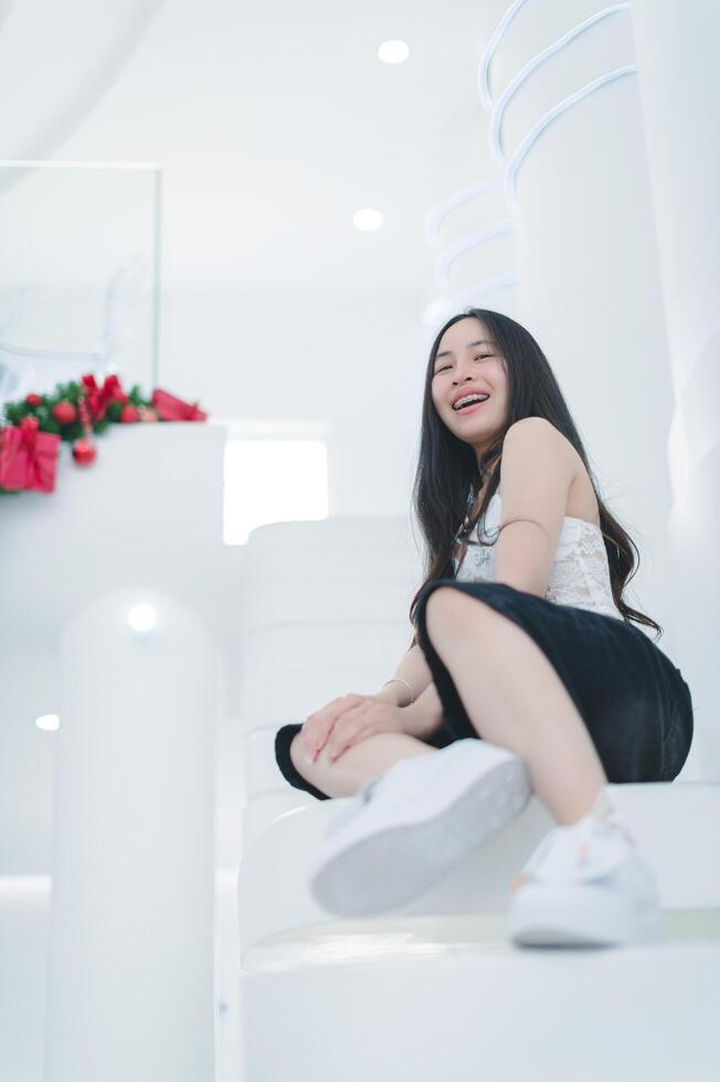 Joyful Young Woman Sitting on White Stairs in Bright Space photo