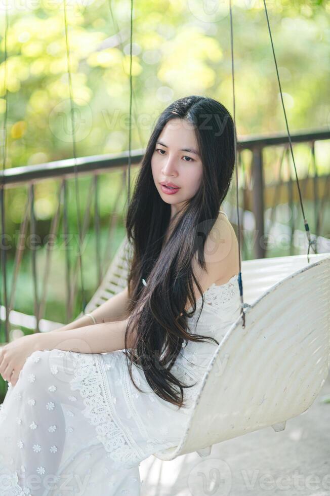 Young Woman Sitting on Swing in Beautiful Outdoor Setting photo