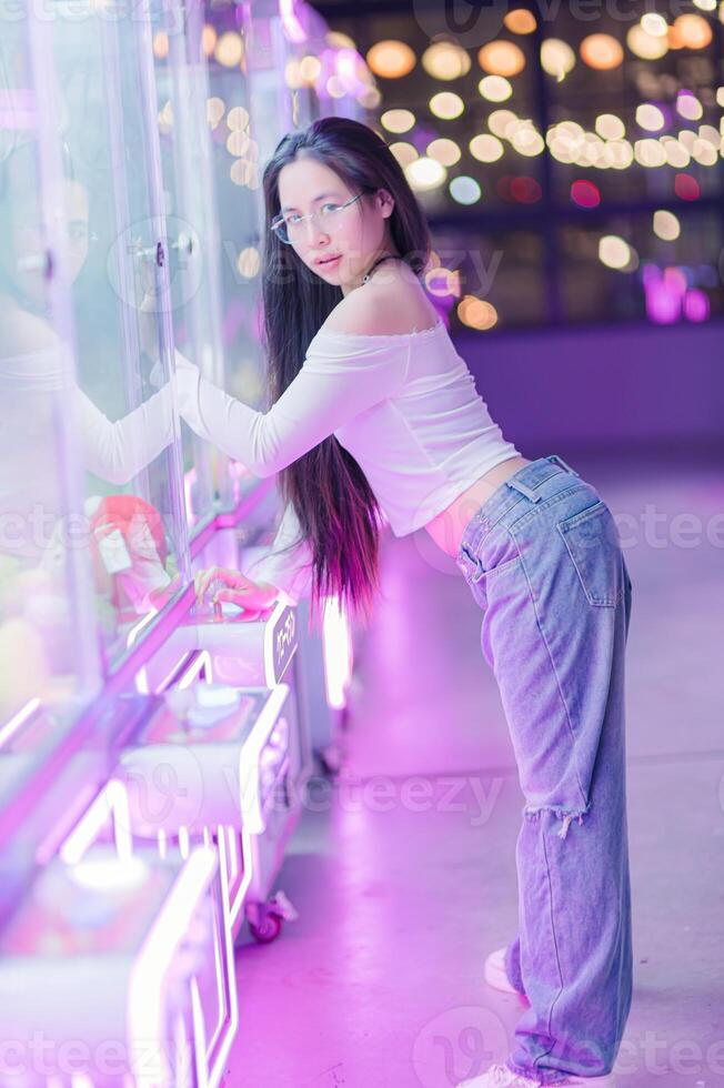Young Woman Posing Near Bright Neon Lights in Amusement Space photo