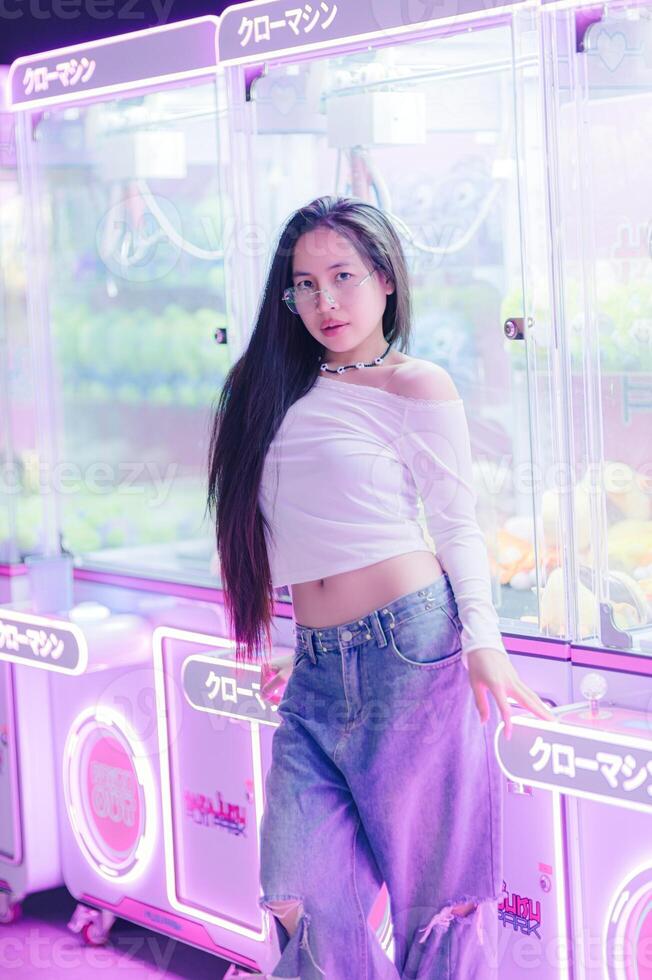 Young Woman Posing in Arcade with Neon Lights and Claw Machines photo
