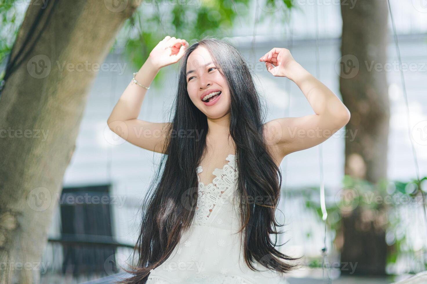 Joyful woman swinging outdoors with long hair and bright smile photo
