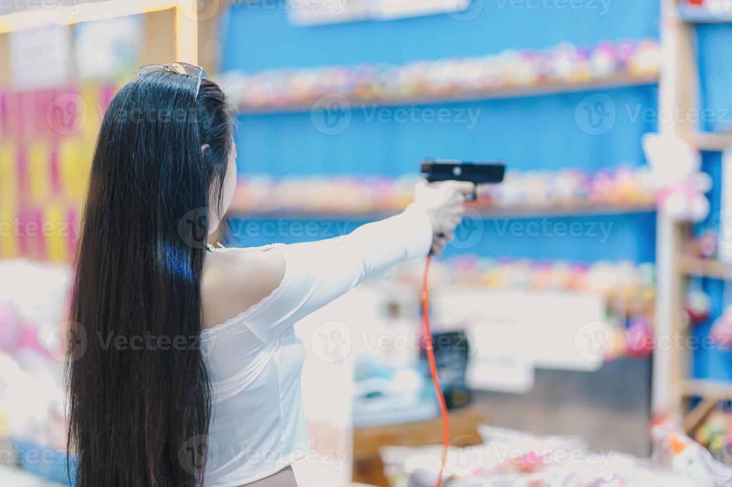 Woman Aiming Toy Gun in Colorful Arcade Game Environment photo