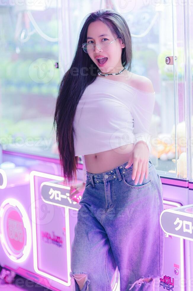 Young Woman Posing Playfully in Casual Outfit with Neon Lights photo