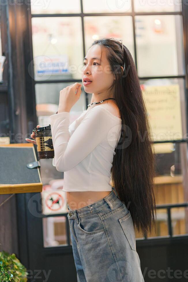 Young Woman with Long Hair in Casual Outfit at a Coffee Shop photo