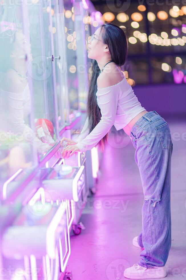 Young Woman Enjoying Fun at Amusement Arcade with Neon Lights photo