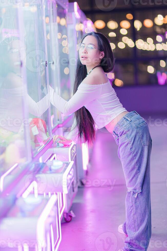 Young Woman in Casual Outfit at Neon-lit Game Arcade Display photo