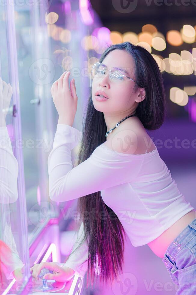 Young Woman Posing by Glass Showcase with Neon Lights and Bokeh photo