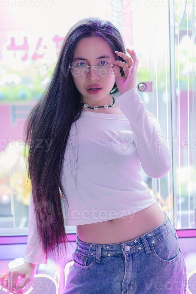 Young Woman in Trendy Outfit Posing in Colorful Urban Environment photo