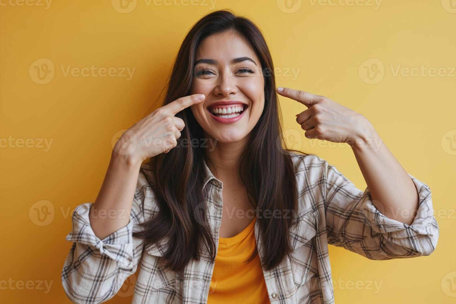 Portrait of Smiling Woman Gesturing towards Cheeks photo