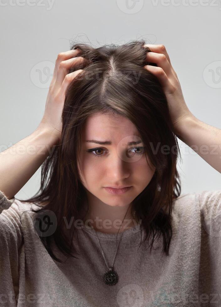 Young woman looking down with a troubled expression photo