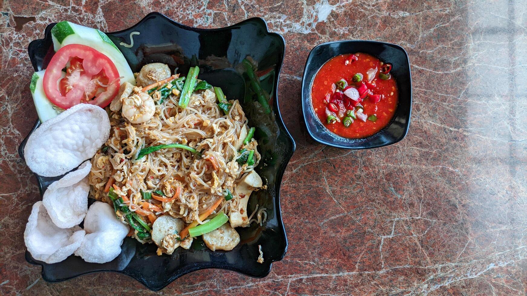 Selective focus of fried seafood vermicelli with spicy tomato sauce is good for breakfast. photo