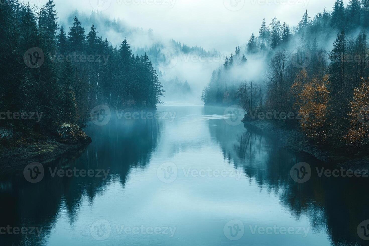 Fog covering coniferous forest and reflecting in calm lake at dawn photo