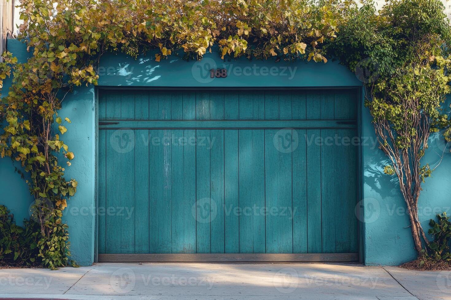 Turquoise garage door with climbing plants and number 168 photo