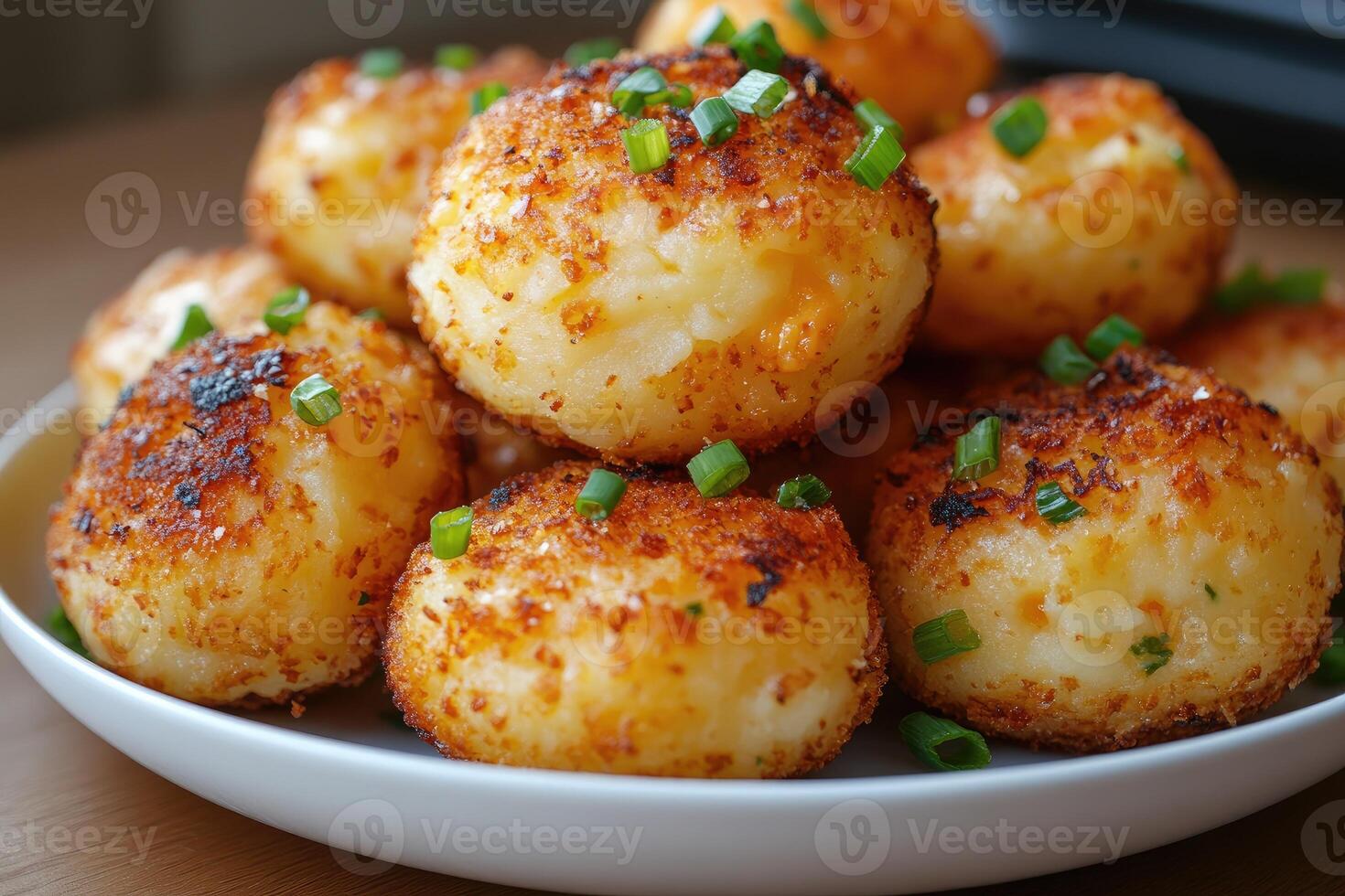 Fried potato pancakes sprinkled with chopped chives resting on dark plate. photo