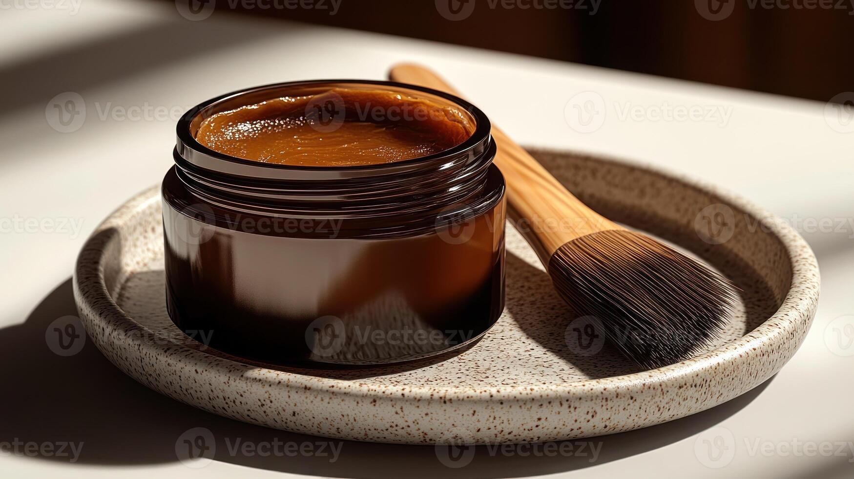 A rich brown cream nestled in an elegant jar with a brush ready for application photo