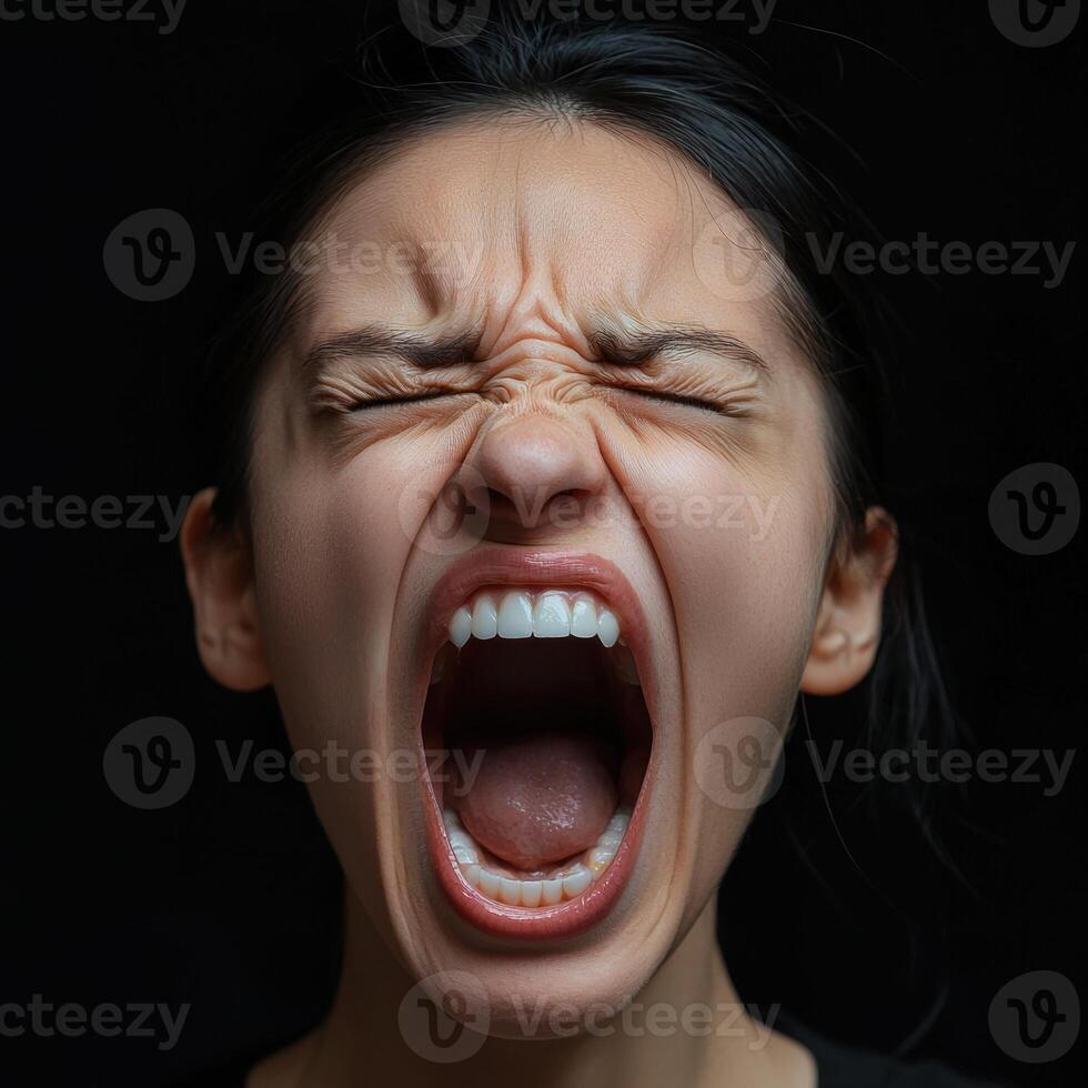 Close up of a woman screaming with eyes closed photo