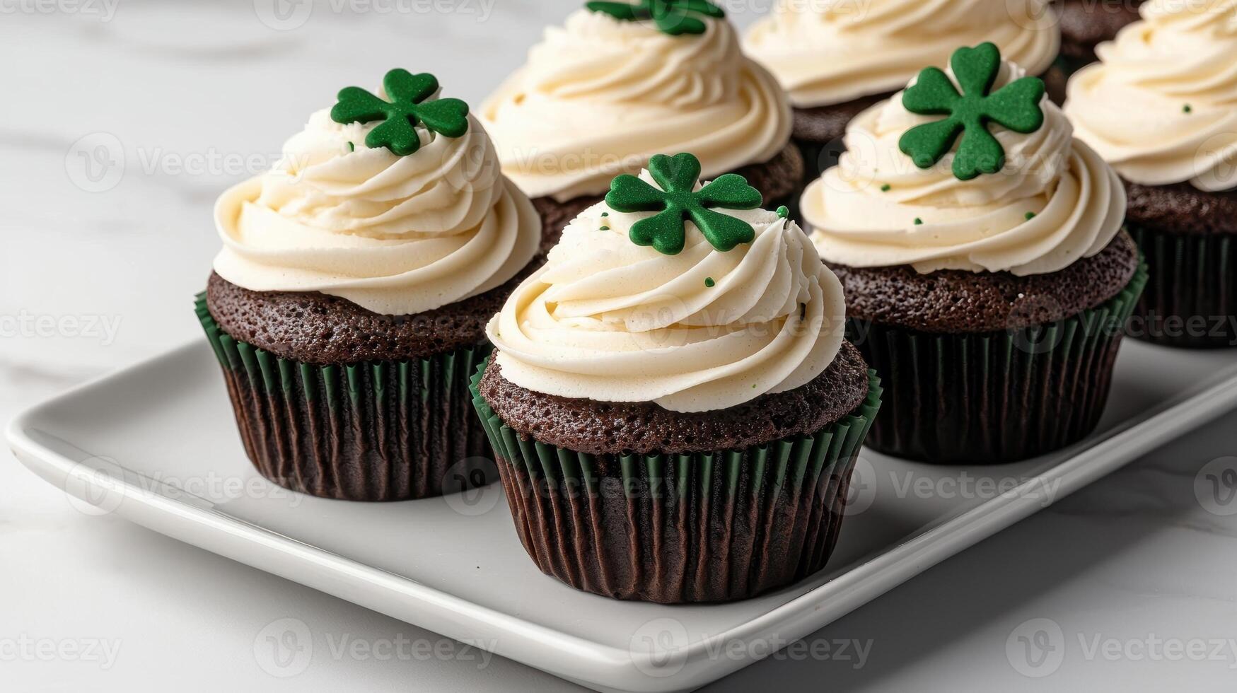 Closeup of delicious chocolate cupcakes with vanilla frosting and shamrock decorations photo