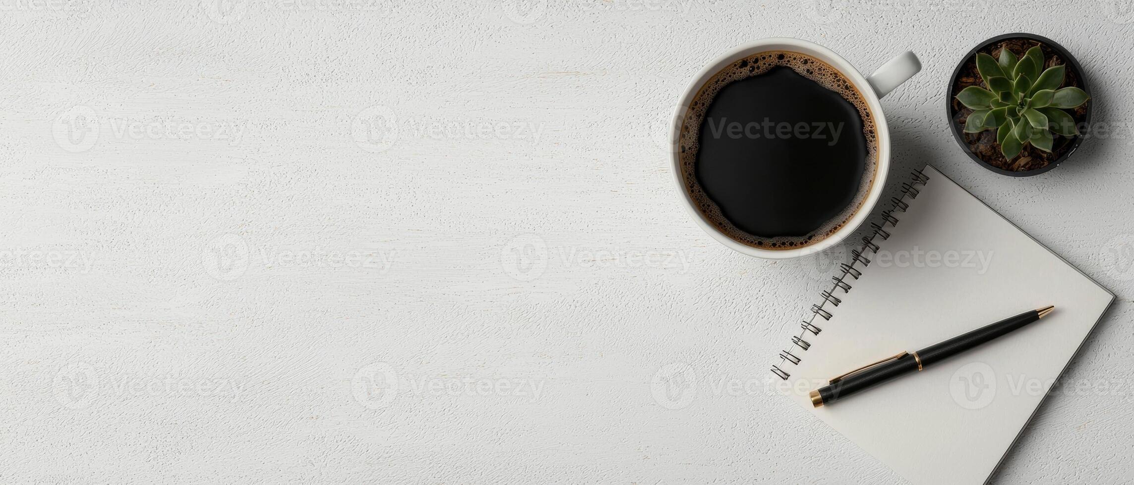 Overhead view of a workspace with coffee, notebook, and succulent photo