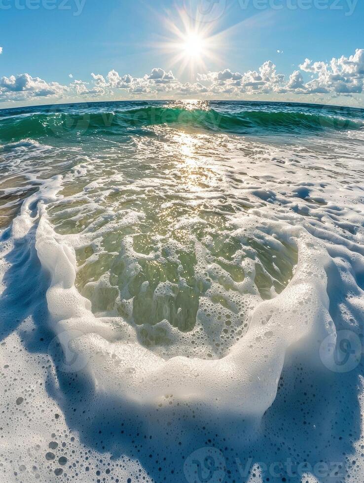 Ocean wave crashing on sandy beach, sun shining bright photo