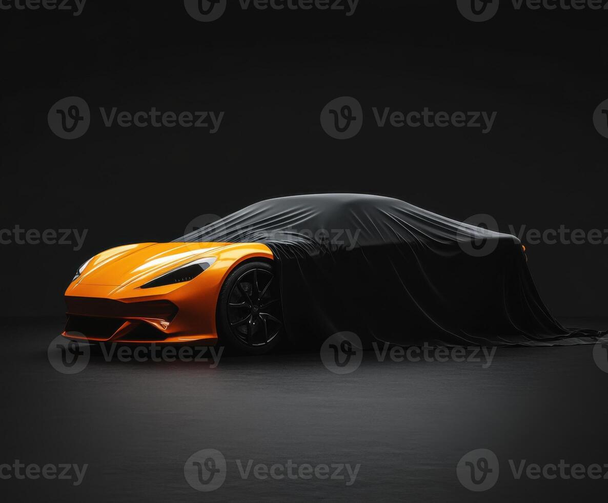 Brand new sports car partially covered with a black cloth in a dark studio setting photo