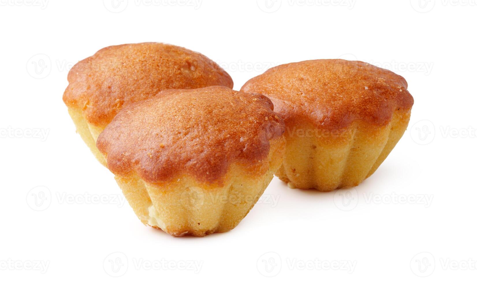 Bakery treats on a white background highlighting three golden mini cakes with a smooth texture photo